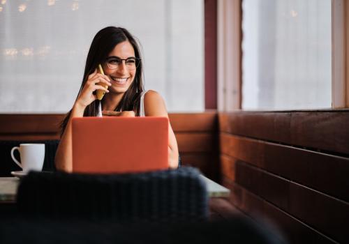 Foto de mujer sonriendo frente a una computadora