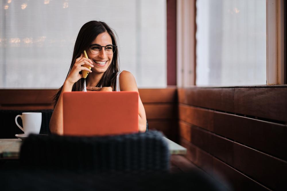 Foto de mujer sonriendo frente a una computadora